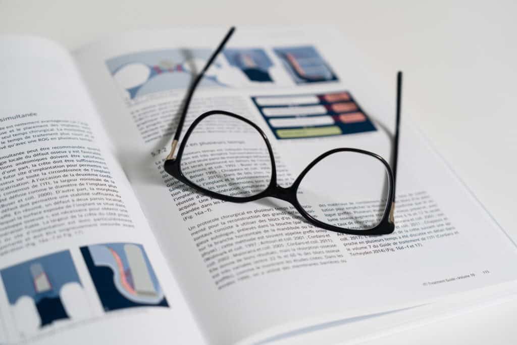 Eyeglasses resting on an open magazine with eye care and vision correction content, highlighting Ardentis' focus on advanced eye health services.
