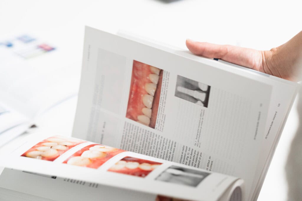 Consultation d’un guide clinique illustrant des cas d’implants dentaires