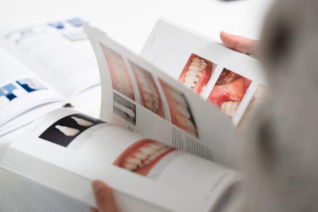 Dental consultation with printed dental images and brochures at Ardentis clinic.