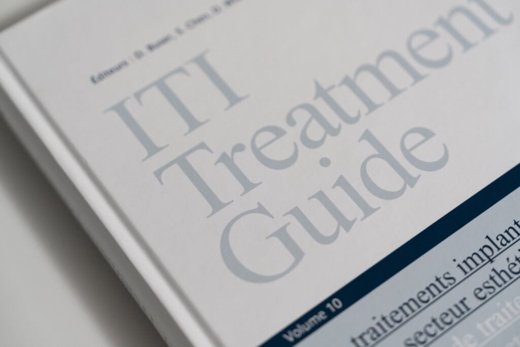 Ardentis dental clinic logo on a printed IT Treatment Guide, emphasizing advanced dental care and implant treatments.