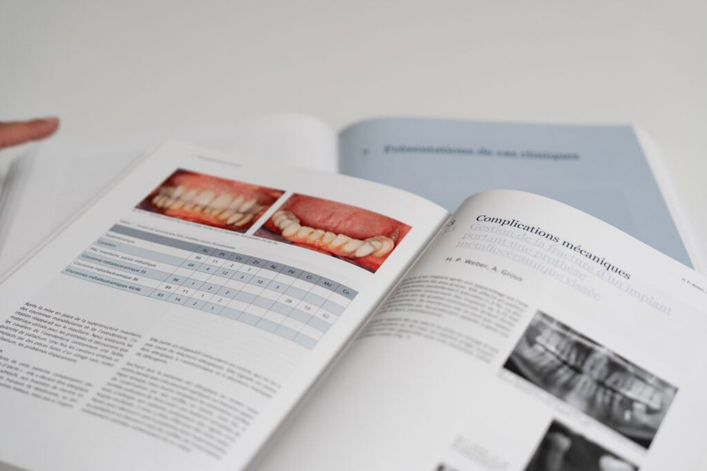 Ouvrage d’implantologie ouvert avec images cliniques et radiographiques