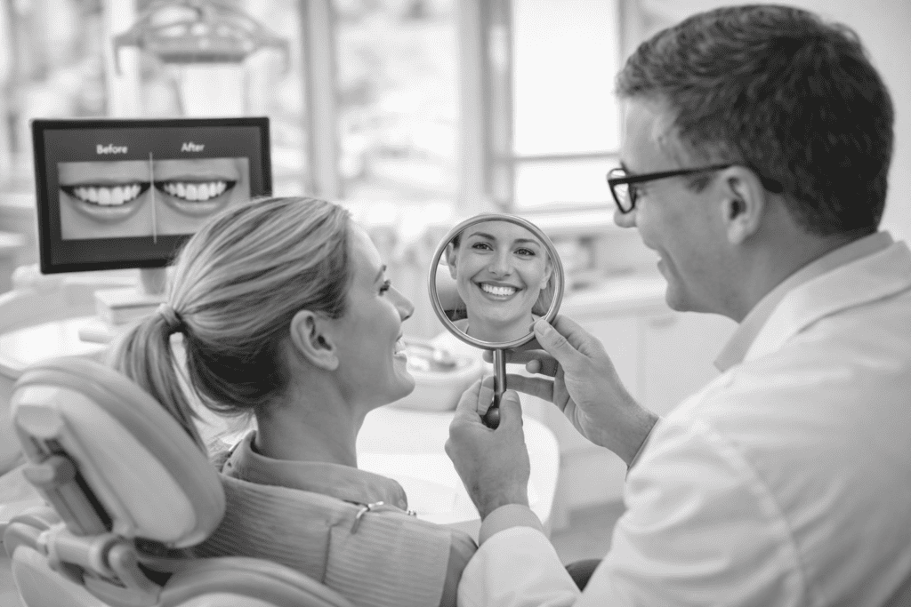 Dentiste montrant le résultat du sourire à une patiente à l’aide d’un miroir