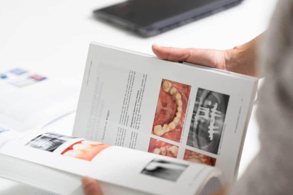 Dentist reviewing dental X-rays and oral health images on a tablet during a consultation at Ardentis dental clinic.