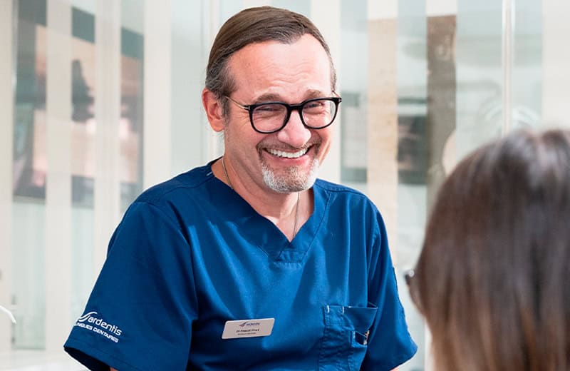 Médecin dentiste souriant en consultation avec une patiente