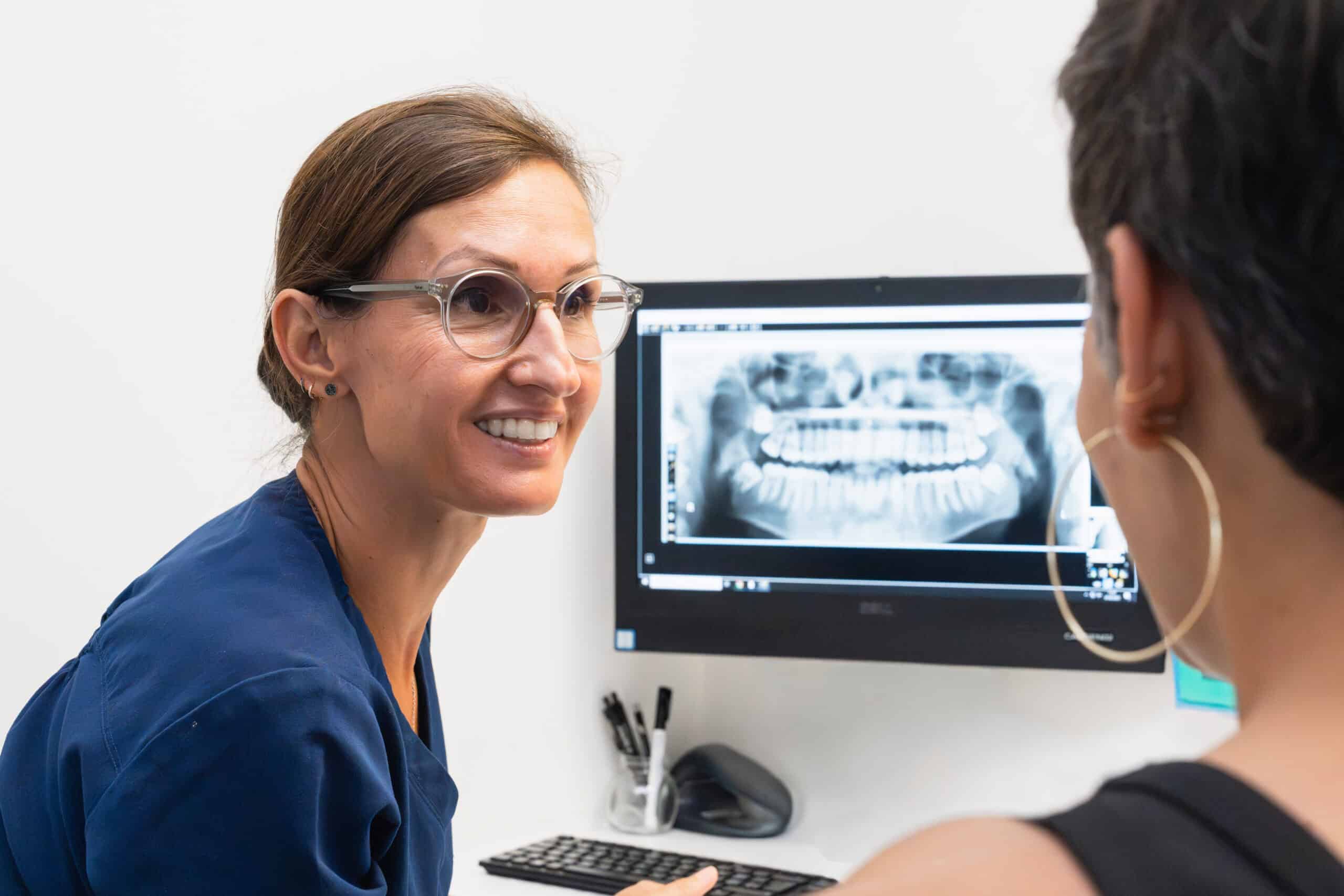 Dentiste expliquant une radiographie dentaire à une patiente