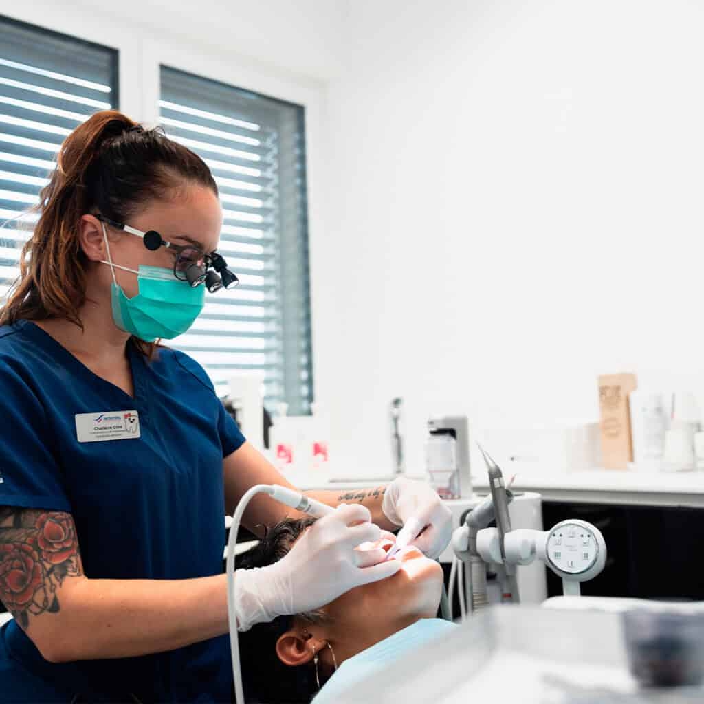 Dentiste utilisant un microscope pour un traitement précis et efficace.