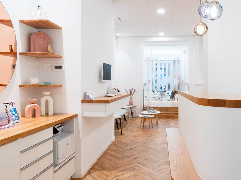 Espace de consultation dentaire moderne avec mobilier épuré, ambiance lumineuse et décoration chaleureuse chez Ardentis à Genève.
