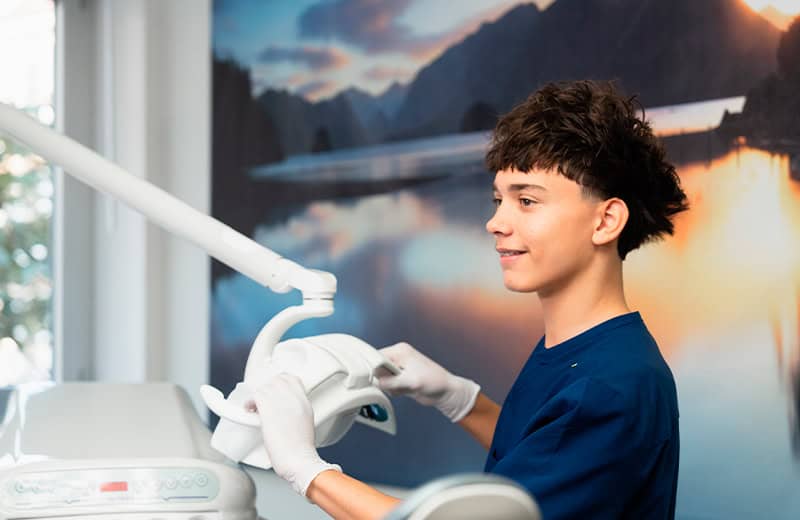 Young male dental patient receiving treatment with advanced dental equipment at Ardentis dental clinic, showcasing modern dental care.