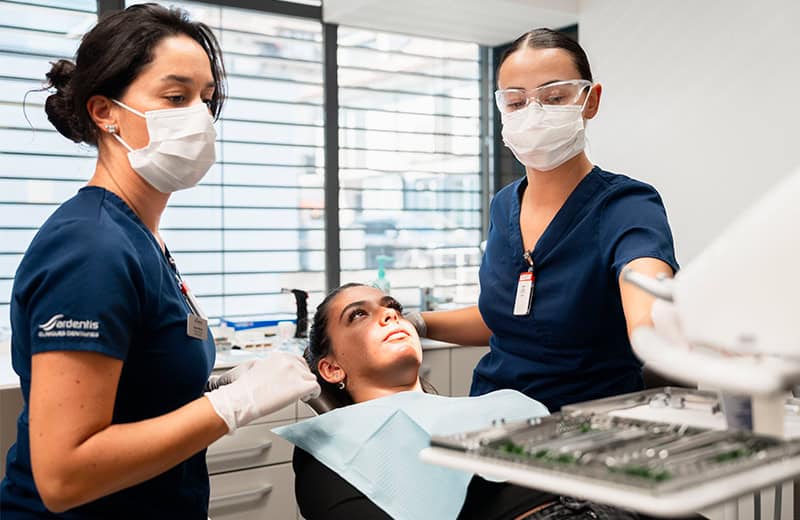 Dental professionals performing a procedure on a patient in a modern clinic setting.