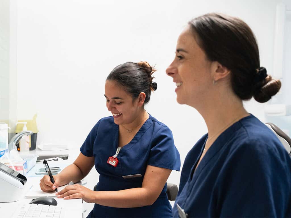 Prise en charge dentaire par des professionnelles souriantes chez Ardentis, clinique dentaire moderne et accueillante.