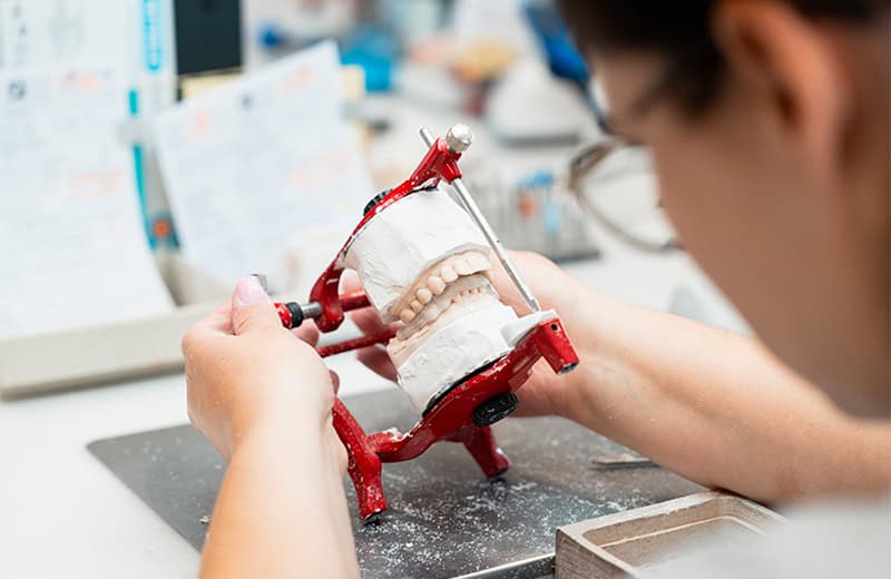 Dental model being adjusted with orthodontic tools, showcasing dental care and orthodontic expertise at Ardentis.