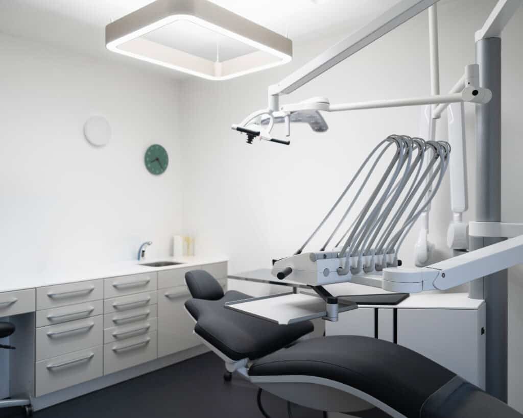 Modern dental clinic treatment room with advanced dental chair and equipment.