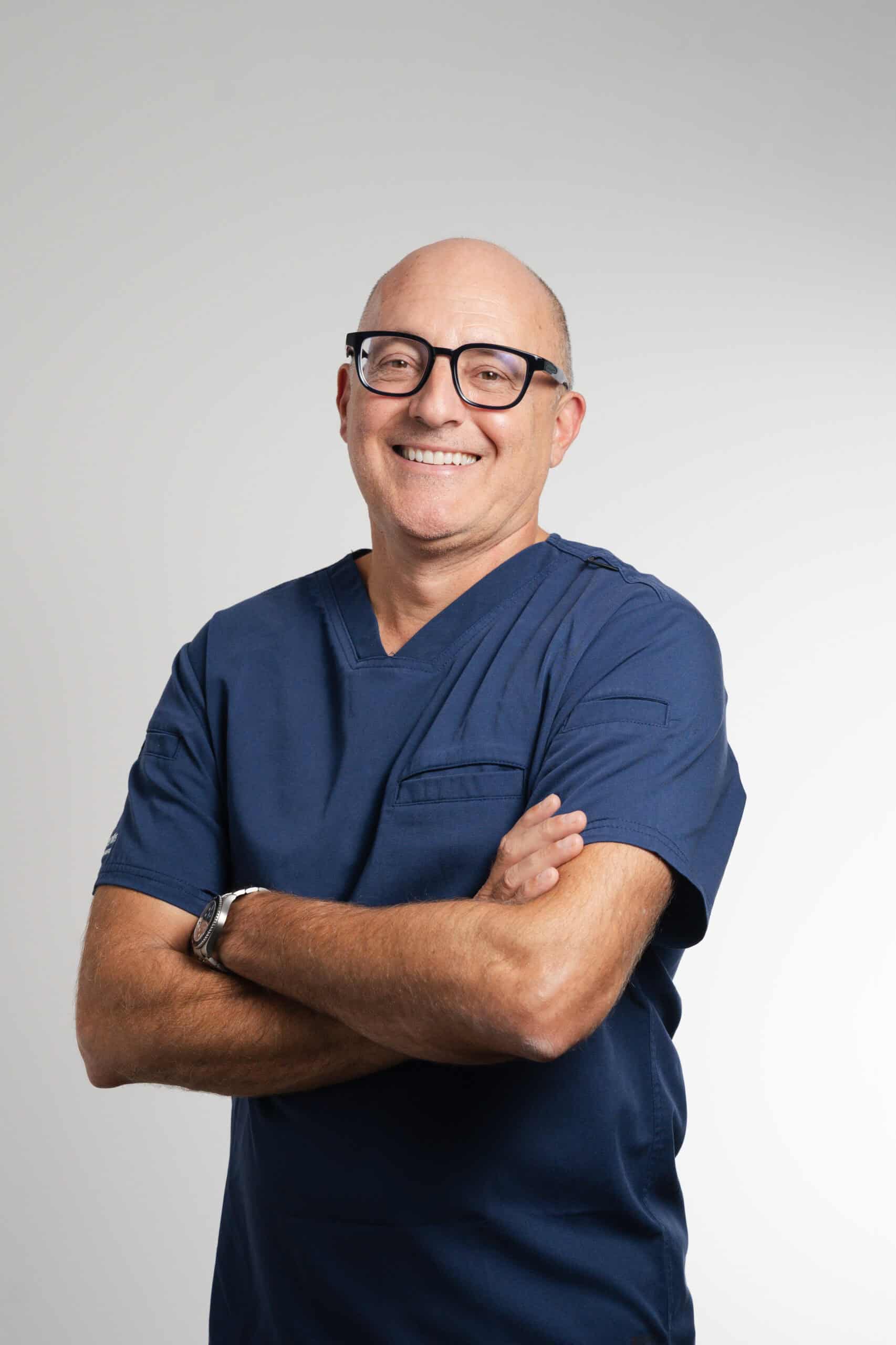 Dr Mark Bischof, dentiste Ardentis en tenue médicale bleue