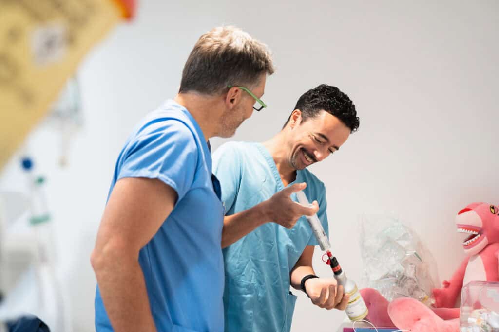 Two dental professionals smiling and discussing a dental procedure in a modern clinic, emphasizing patient care and dental expertise.