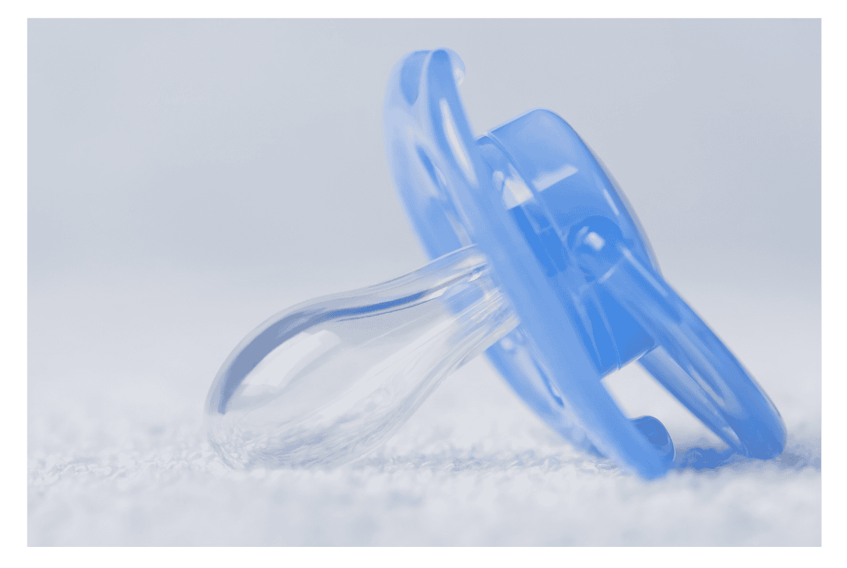 Poupée de bébé en silicone avec tétine en plastique bleu, vue détaillée.
