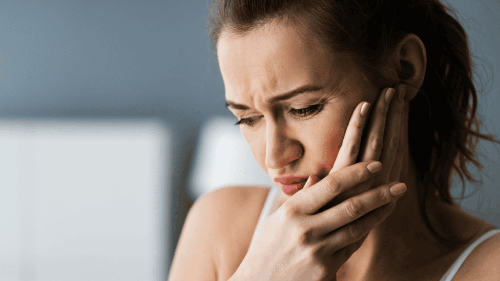 Femme souffrant de douleur dentaire, expression de malaise et d'inconfort buccal.