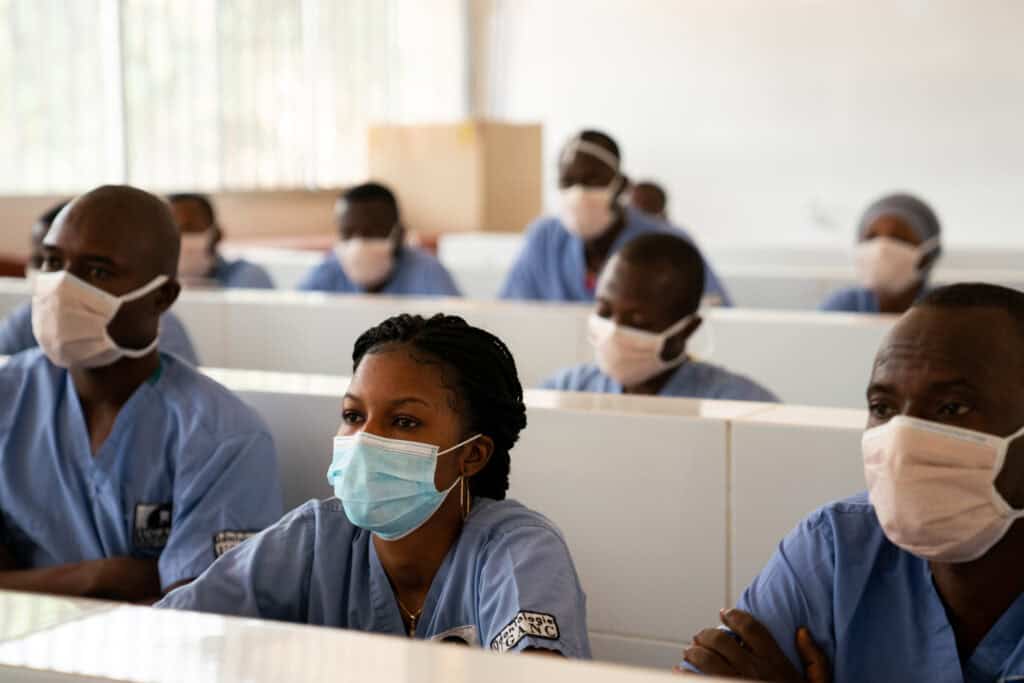 Étudiants en formation médicale portant des masques dans une salle de classe.
